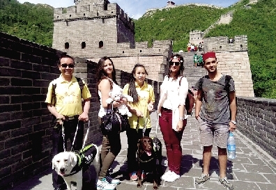 兩位盲人和導(dǎo)盲犬在長城上與外國游客合影 受訪者供圖